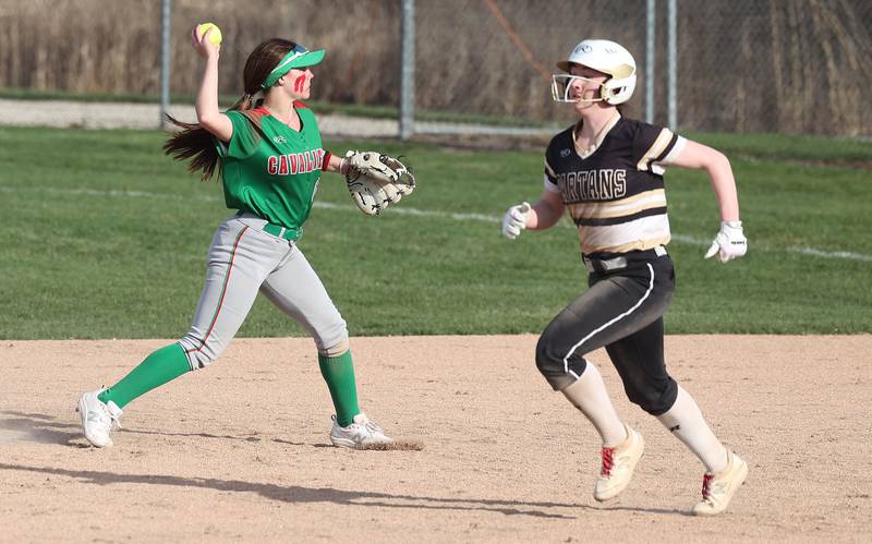 LaSalle-Peru's Callie Mertes throws to first as Sycamore's Tia Durst runs by during their game Tuesday, April 11, 2023, at Sycamore High School.