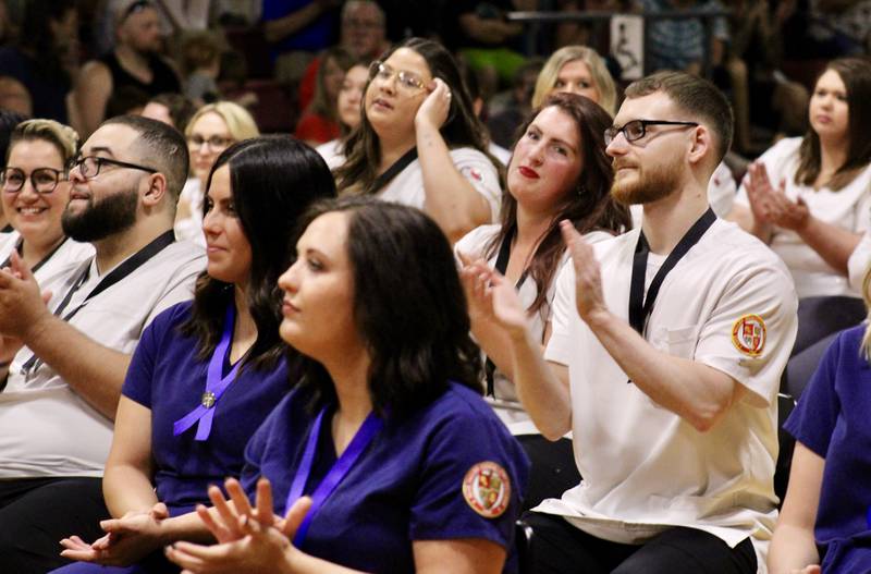 Classmates in the division of health professions applaud as one of their own receives their nursing pin on Friday at Sauk Valley Community College.