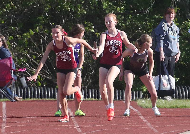 Morris's Ava Conley receives the baton from teammate Leah Martin in the 4x100 relay during the Interstate 8 Conference girls track championship on Friday, May 9, 2025 at Morris High School.