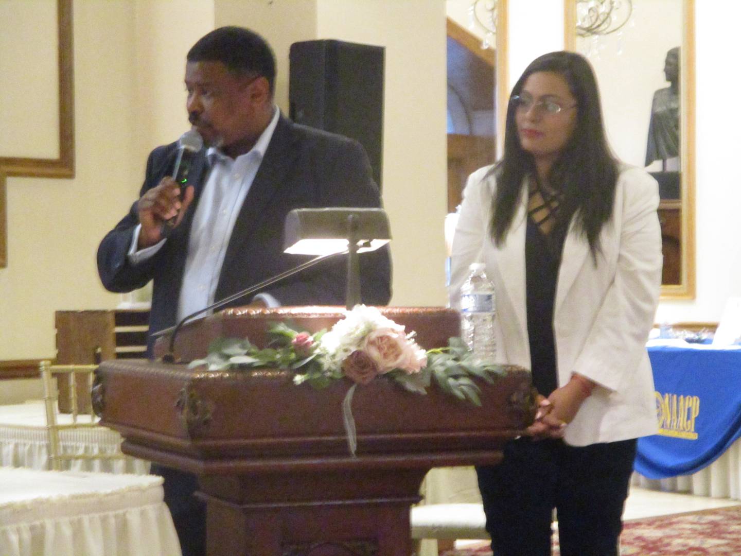 NAACP-Joliet Vice President Marcus Mars (left) and Tanya Arias, president of the Collins Street Neighborhood Council, greet candidates at a forum held Wednesday at the Jacob Henry Mansion Estate in Joliet. March 19, 2025