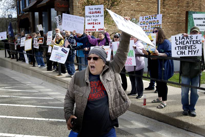 Luella Jaslowski leads protesters in a chant as they line U.S. Route 12 in Richmond to protest their discontent with President Donald Trump and his administration's policies on Saturday, April 19, 2025. Over 100, people took part in the Richmond protest. A second rally was held in Harvard later in the day.