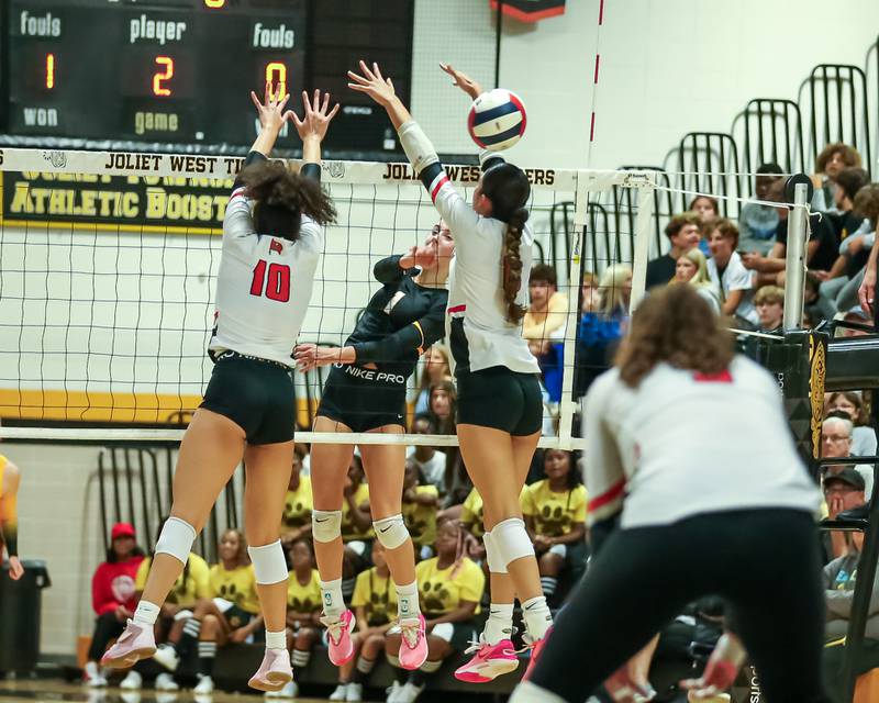 Joliet West's Ava Grevengoed (1) hits a kill shot between he arms of Bolingbrook's Sophia Barrera (5) during regional final volleyball match between Bolingbrook at Joliet West.  Oct 26, 2023.