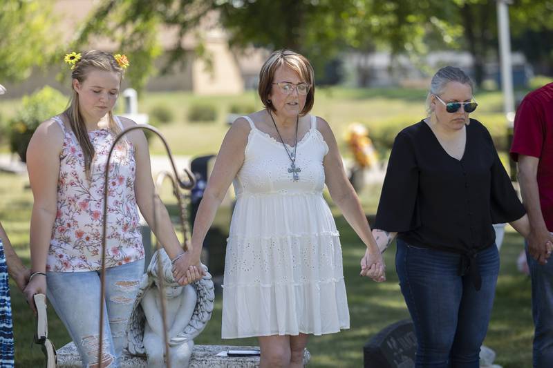 Nicci Wright (middle) and family joins hands while praying for her mom Friday, July 7, 2023.