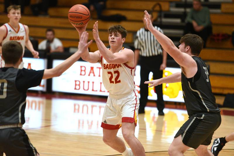 Batavia's Charlie Whelpley (22) passes under pressure from the Glenbard North defense during Tuesday’s boys basketball game in Batavia.