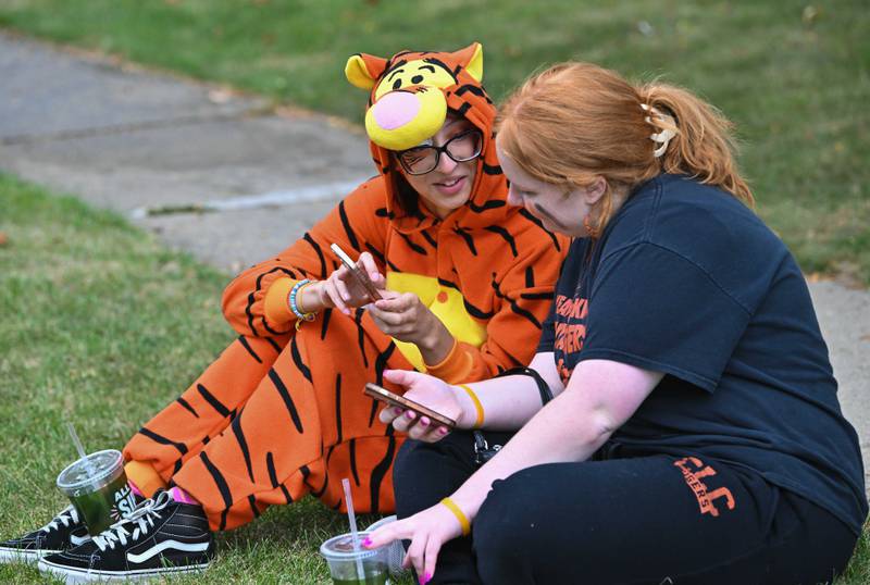 Crystal Lake Central High School students Franshaska Taylor ('24) and Amanda Kasenter ('24)' sit along the parade route to celebrate Crystal Lake Central's 100 year anniversary homecoming day on Saturday, Sep. 16, 2023 in Crystal Lake. The parade began at the high school and made its way through downtown Crystal Lake.