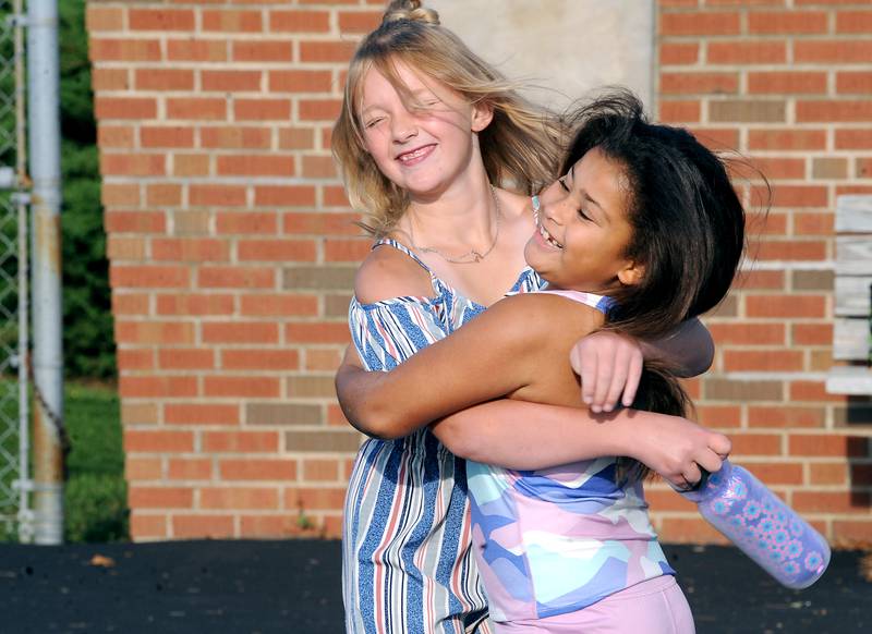 "We really missed each other," said third-grader Jordyn Freeland (right) as she gives a giant hug to friend Lily Roy on the first day of school at Haskin Elementary in Sandwich on Wednesday, Aug. 17, 2023.