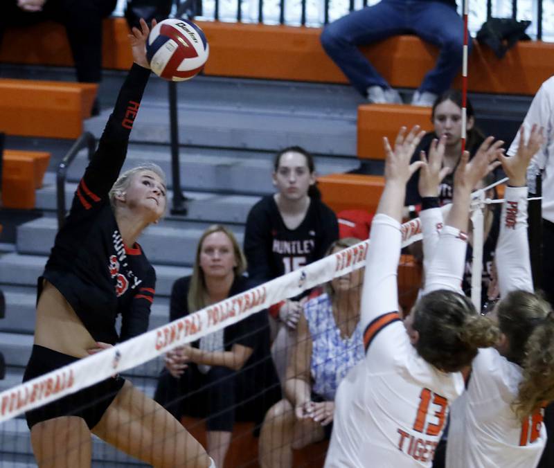 Huntley’s Ally Panzolff, left, spikes the ball as Crystal Lake Central’s Siena Smiejek, center, and Anna Starr, right, during a Fox Valley Conference volleyball match Tuesday, Aug. 23, 2022, between Crystal Lake Central and Huntley at Crystal Lake Central High School.