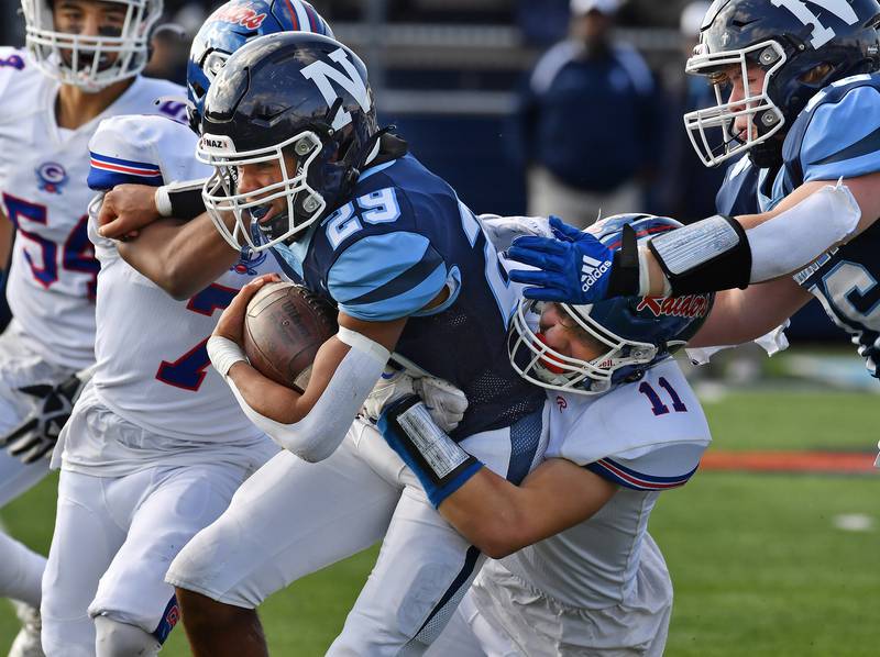 Nazareth's Charles Calhoun (29) drags two Glenbard South defenders for extra yardage during a Class 5A second round game on Nov. 4, 2023 at Nazareth Academy in LaGrange Park.