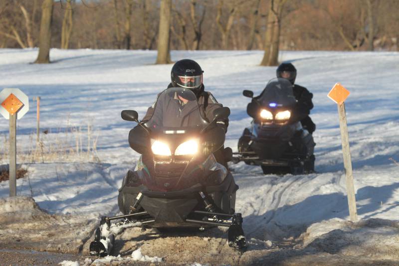 In this file photo, Paul Hettich and Tim Fitch, Lake County Forest Preserves ranger police officers, snowmobile in the Lakewood Forest Preserve in Wauconda.