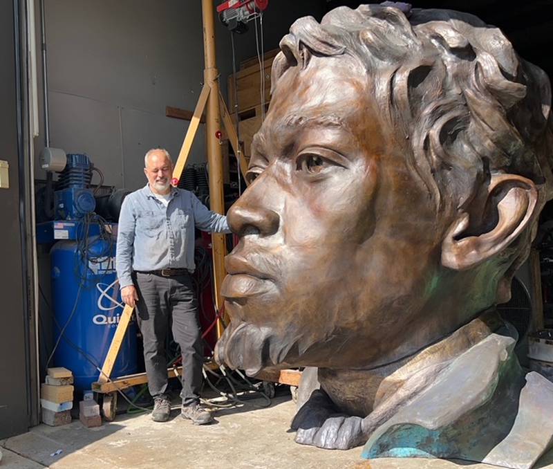 Crystal Lake-based artist Erik Blome stands with his 8.5-foot tall DuSable sculpture at his Woodstock studio.