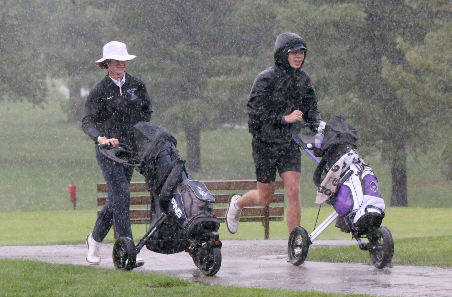 Fieldcrest's Nathan Buchanan and Roanoke-Benson's Kaden Harms runs to the clubhouse in the pouring down rain  during the Class 1A Regional on Wednesday, Sept. 27, 2023 at Wolf Creek Golf Club in Pontiac.