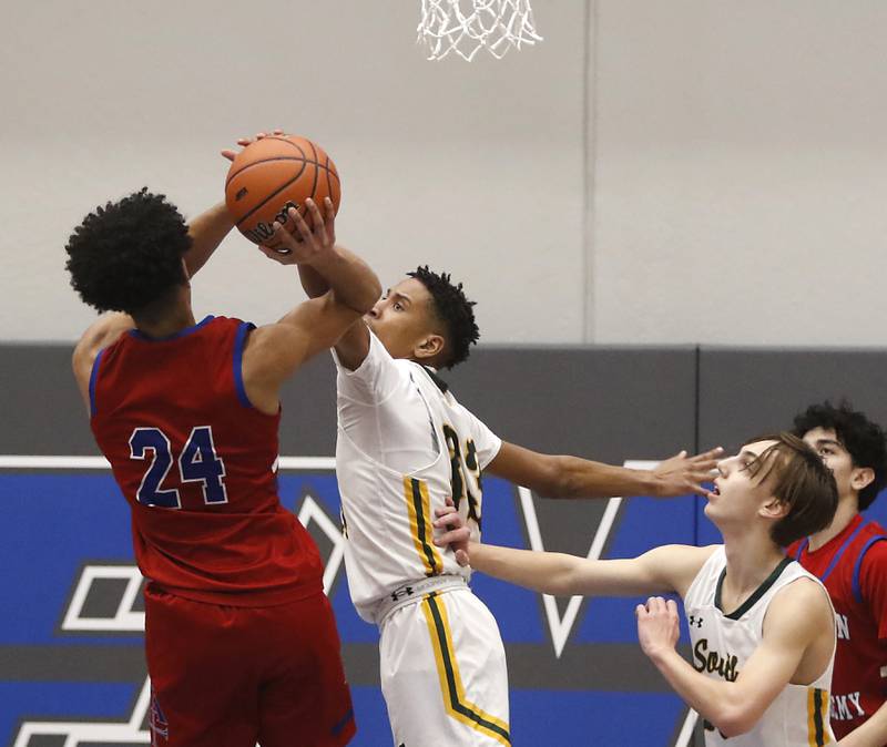 Crystal Lake South's Christian Rohde blocks the shot of Marmion’s Trevon Roots during a IHSA Class 3A Sectional boys basketball game Tuesday, Feb. 28, 2023, at Central High School in Burlington.