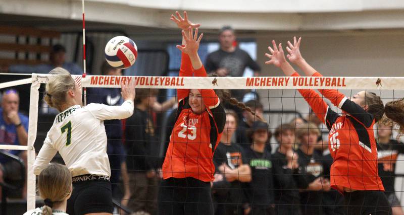 Crystal Lake South’s Gabby Wire, left, tries to get the ball past McHenry’s Mollie Hobson, center, and Sophie Zieba in varsity volleyball at McHenry Tuesday night.