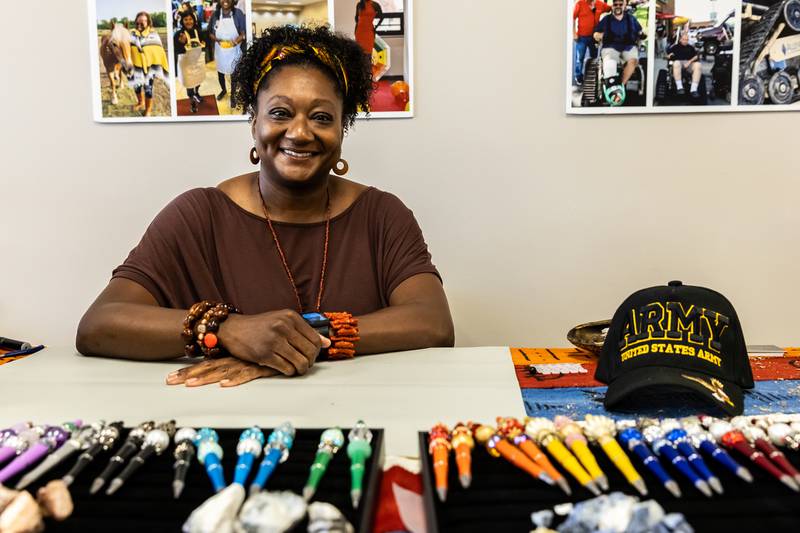 Army veteran Oluwatoyin Olabisi hosts a booth during AllenForce's grand opening event celebrating the new Veteran Wellness & Recreation Center in Joliet on July 25, 2025.