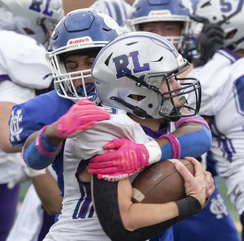 Newman’s Tyson Williams wraps up Ridgeview-Lexington’s Joe Cheever Saturday, Nov. 1, 2025, in round one of the Class 2A football playoffs.