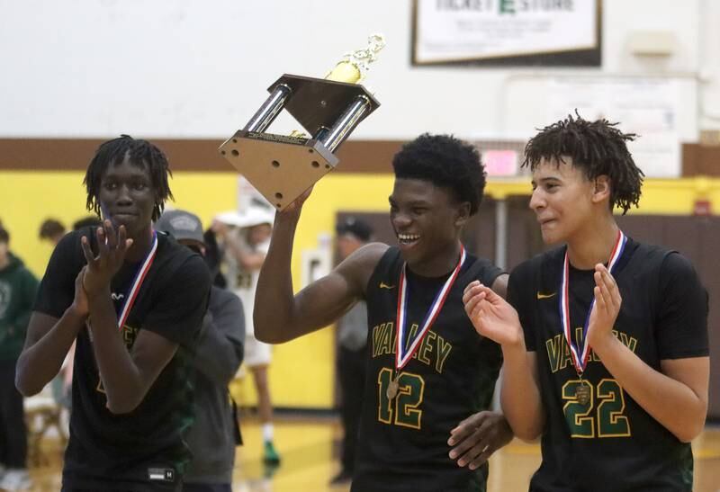 From left, Waubonsie Valley’s Moses Wilson, Tyreek Coleman and Kris Mporokoso accept their first-place trophy after Hinkle Holiday Classic varsity boys basketball tournament title game action on Friday, Dec. 27, 2024 at Jacobs High School in Algonquin. The Warriors won against Crystal Lake South.