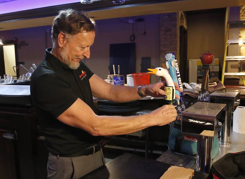 Rhett Wilborn instals a tap on Friday, June 14, 2024, as the Foxhole Pizza and Pub in McHenry prepares to reopen under new ownership.