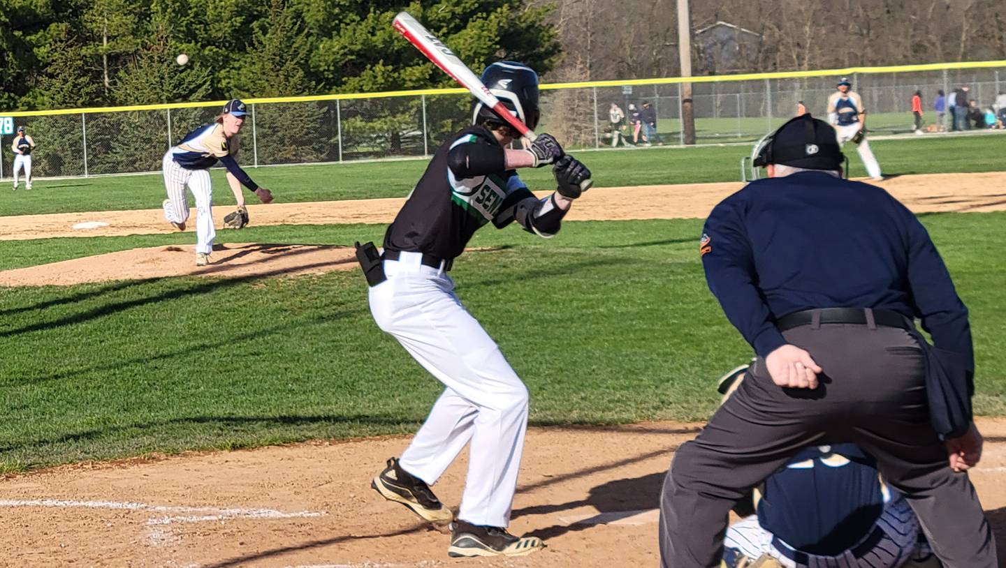 Marquette's Logan Nelson (left) fires a pitch to a Seneca batter during the 2022 season.