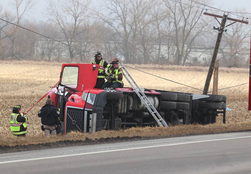 Cortland firefighters and police work to secure the cab of a semitrailer that rolled into the ditch Wednesday, Jan. 7, 2026, on the north side of Lincoln Highway in Cortland.
