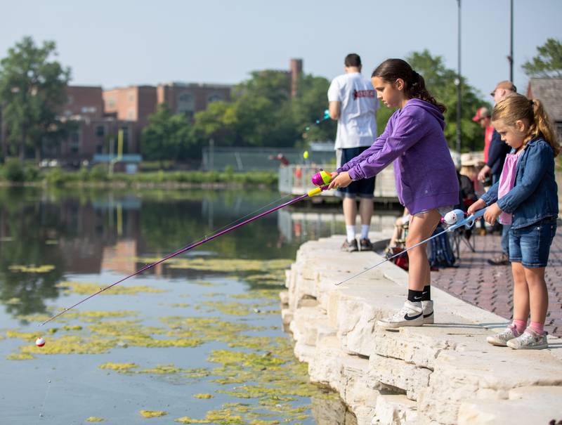 Sofia (4), right, and Emma (8) Koscik fish together during the Glen Ellyn Park District's Gone Fishin' Derby at the Lake Ellyn Boathouse in Glen Ellyn on Saturday, June 18, 2023.