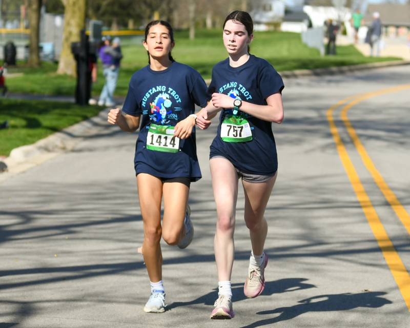 Nia Ortega of Downers Grove, 1414, and Jane Fallon of Naperville finish the Mustang Trot race on Sunday April 14, 2024, held at Downers Grove South High School.