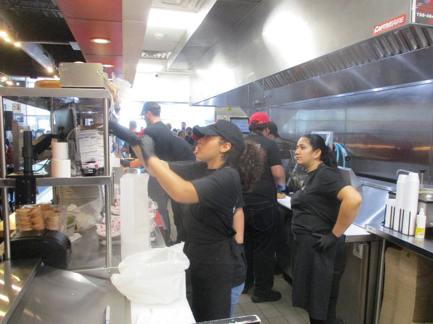 The kitchen crew at Fry the Coop in Joliet keep the free chicken sandwiches coming during a grand opening on Thursday. Aug. 14, 2025