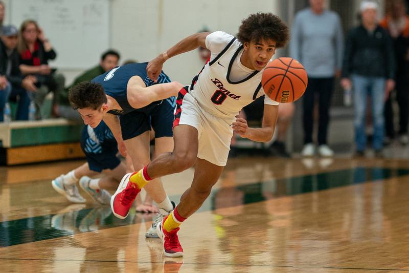 Benet’s Brayden Fagbemi (0) chases down a loose ball against Lake Park's Camden Cerese (1) during a Bartlett 4A Sectional semifinal boys basketball game at Bartlett High School on Tuesday, Feb 28, 2023.