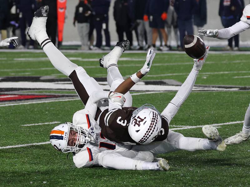 Mount Carmel's Marshaun Thornton can’t quite corral the reception as Oswego's Jake Walsh pulls him down Wednesday, Dec. 3, 2025, during their IHSA Class 8A state chamionship game in Huskie Stadium at Northern Illinois University in DeKalb.