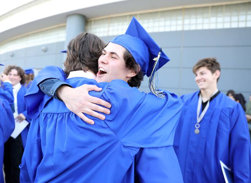St. Charles North graduate Tony Vicacqua hugs a classmate following the school’s 2023 commencement ceremony at Northern Illinois University in DeKalb on Monday, May 22, 2023.