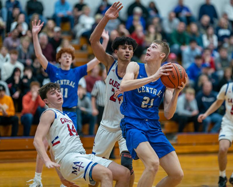 Burlington Central's Andrew Scharnowski (21) plays the ball in the post against Marmion’s Evan Stumm (14) and Trevon Roots (24) during the 59th Annual Plano Christmas Classic basketball tournament championship game at Plano High School on Friday, Dec 30, 2022.