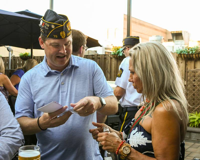 Agnes Schap of Sycamore gets a 50/50 ticket from Bryan Fuller of the Geneva American Legion post on Thursday Aug. 21, 2025, held at Whiskey Bend in St. Charles.