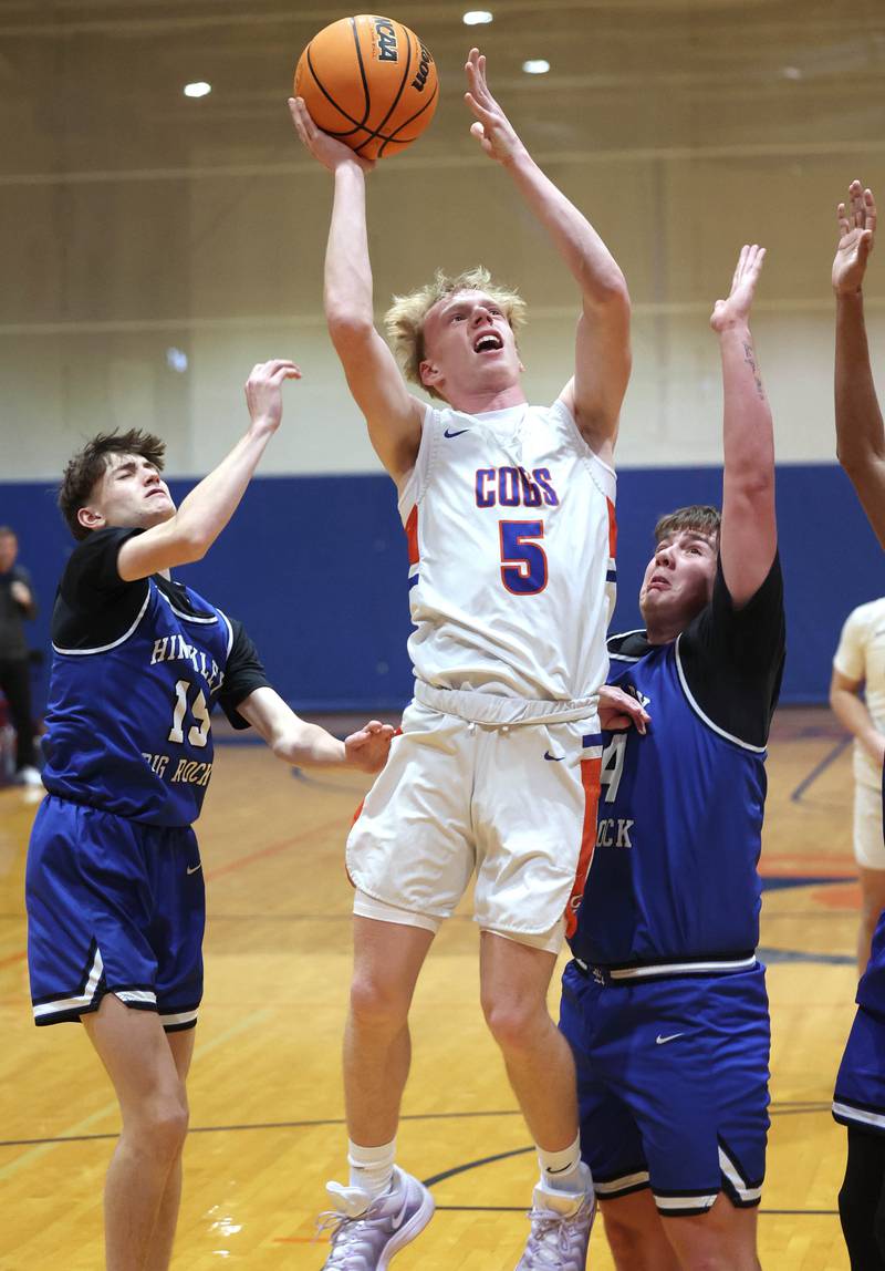Genoa-Kingston's Blake Ides shoots between Hinckley-Big Rock's Gavin Pickert (left) and Luke Badal Tuesday, Jan. 6, 2026, during their game at Genoa-Kingston High School.