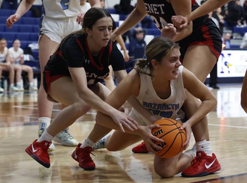 Benet's Ava Mersinger (4) tries to tie up Nazareth's Stella Sakalas (32) during a girls varsity basketball game between Benet and Nazareth academies on Saturday, Dec. 14, 2024 in La Grange Park.