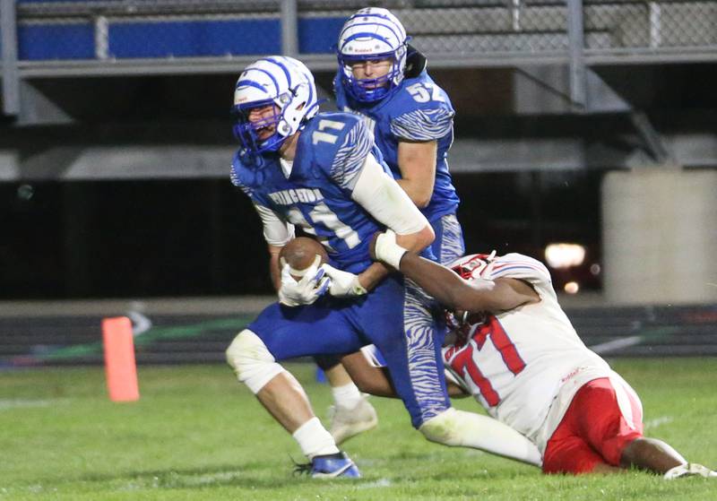 Princeton's Noah LaPorte picks up a loose fumble and is dragged down by Oregon's Kyson Morris during the Class 3A playoff game on Friday, Nov. 1, 2024 at Princeton High School.