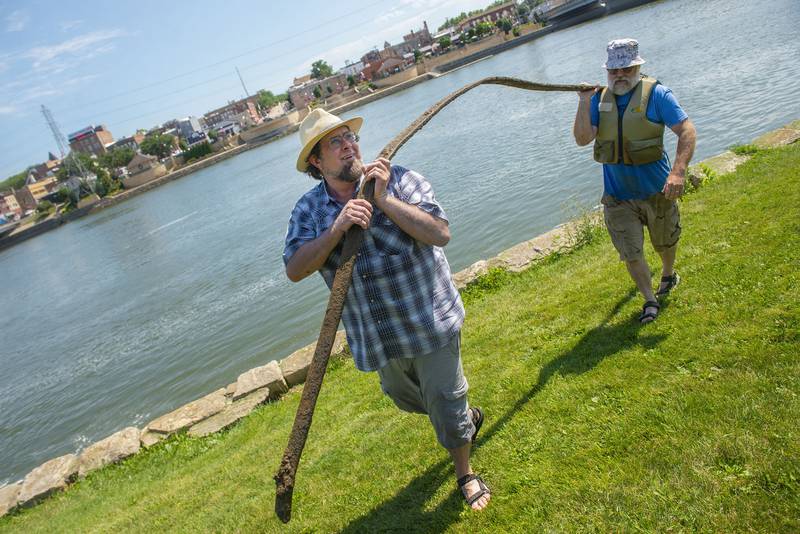 Tim Benedict (left), helps Mark Stach haul in his latest find from the bottom of the Rock River on Tuesday.