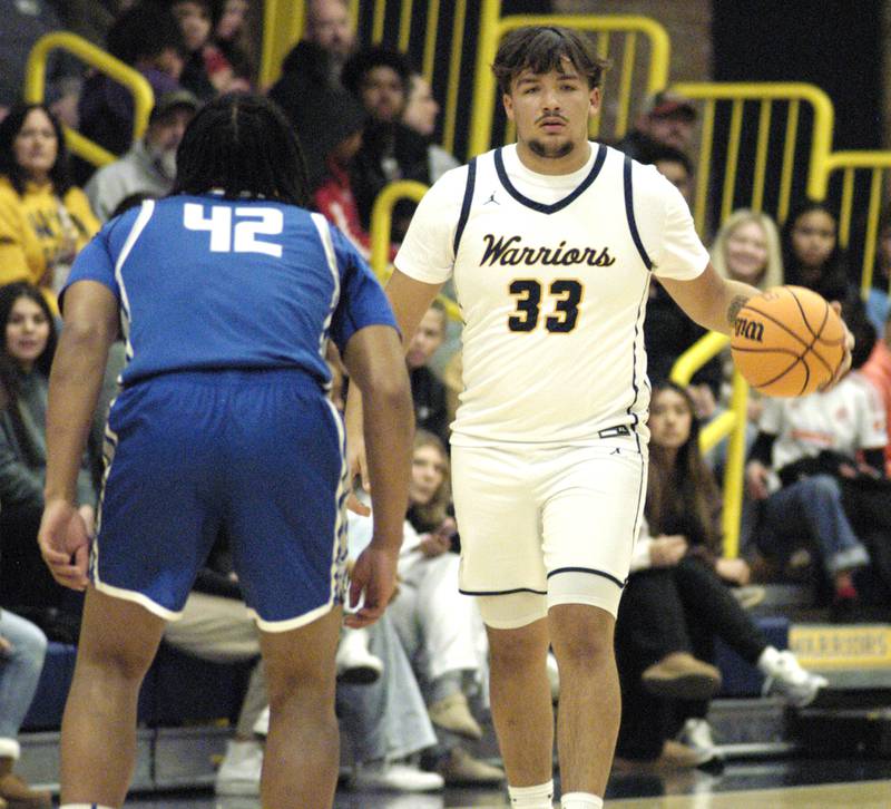 Warrior  Maddox Osborn dribbles ball  aroung Quincy defender Kesshaun Thomas. The action took place on Friday, December 13th at Sterling.