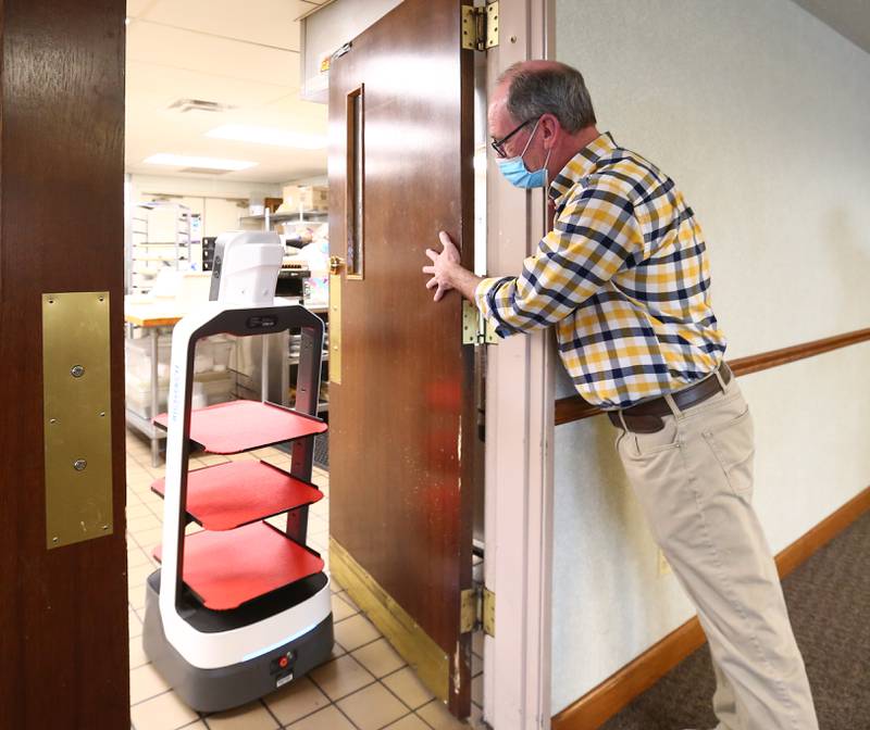 This is something straight out of Star Wars or the Jetsons. Chris Robinson, director of food service at Heritage Woods opens the kitchen door for their new high-tech robot named Rosie on Tuesday Jan. 11, 2022 in Ottawa. It is designed to help assist staff when serving the meals to residence. The robot delivers meals to tables from the kitchen to the tables in the dining room. It has obstacle avoidance that will prevent any accidents. The robot is manufactured by Richtech Robotics and costs $20,000-30,000. It was purchased by a grant.