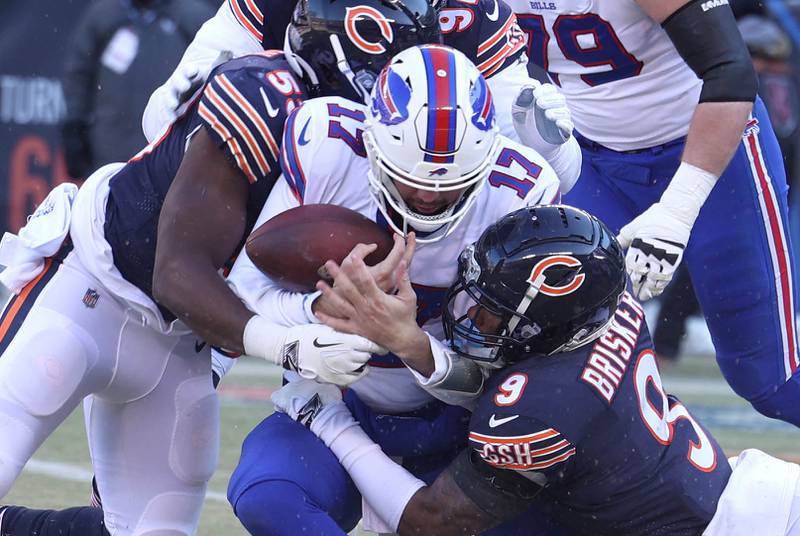 Chicago Bears safety Jaquan Brisker (right) and linebacker Nicholas Morrow bring down Buffalo Bills quarterback Josh Allen during their game Sunday, Dec. 24, 2022, at Soldier Field in Chicago.