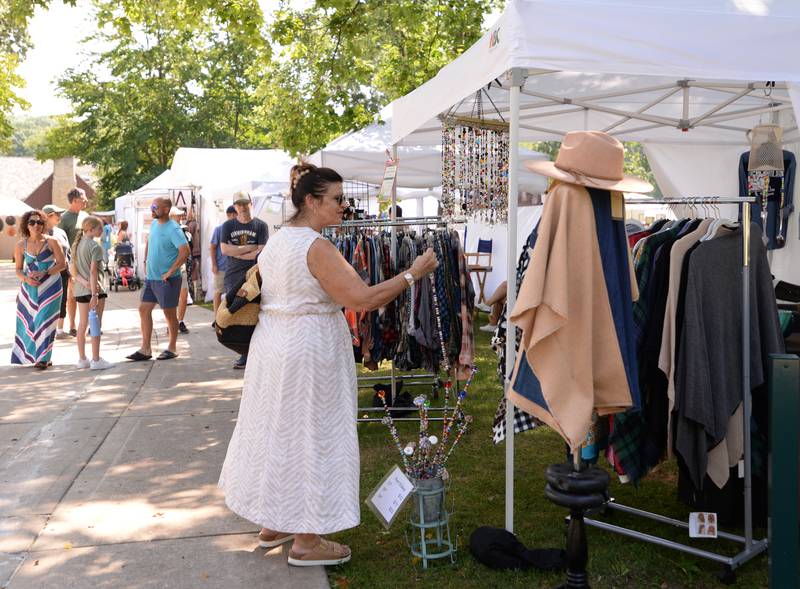Claudia Forester of Glen Ellyn looks at some of the plant stakes for sale during the Glen Ellyn Art Festival on Sunday, Aug 24, 2024 at Lake Ellyn.