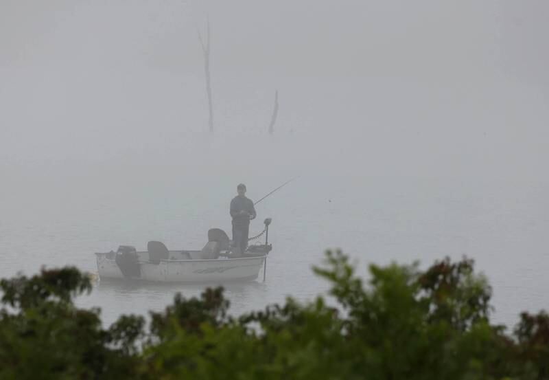 A fisherman tries his luck on a foggy morning Monday, July 22, 2024, in the lake Shabbona Lake State Recreation Area in Shabbona Township.