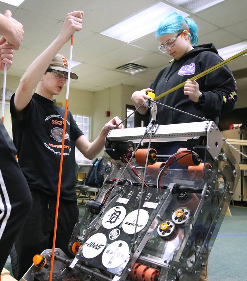 Blake Bollow (left) and Abby Slater, both seniors at DeKalb High School, take some measurements on their team’s robot during a Crowbotics team meeting Tuesday, April 10, 2024, at Huntley Middle School in DeKalb. Crowbotics is DeKalb High School’s robotics team who has qualified to compete in the FIRST Robotics Competition World Championship held in Houston, Texas April 17-20.