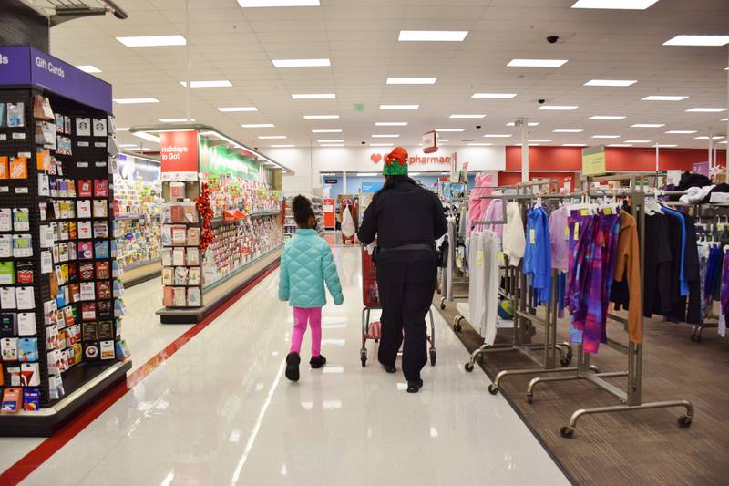Danielle Sorenson, a school resource officer with the DeKalb Police Department, goes shopping for gifts with 8-year-old Amiyah Richardson during the Heroes and Helpers event, held Sunday, Dec. 12, 2021 at the Target store in DeKalb