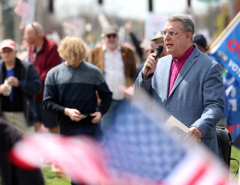 Dave Becker, a Unitarian Universalist minister from DeKalb, speaks to a crowd along Sycamore Road in front of Hopkins Park Saturday, April 19, 2025, during a “No Kings” rally and march in DeKalb. The group was protesting what they’ve argued is the unlawful and harmful federal policies of President Donald Trump and his administration.