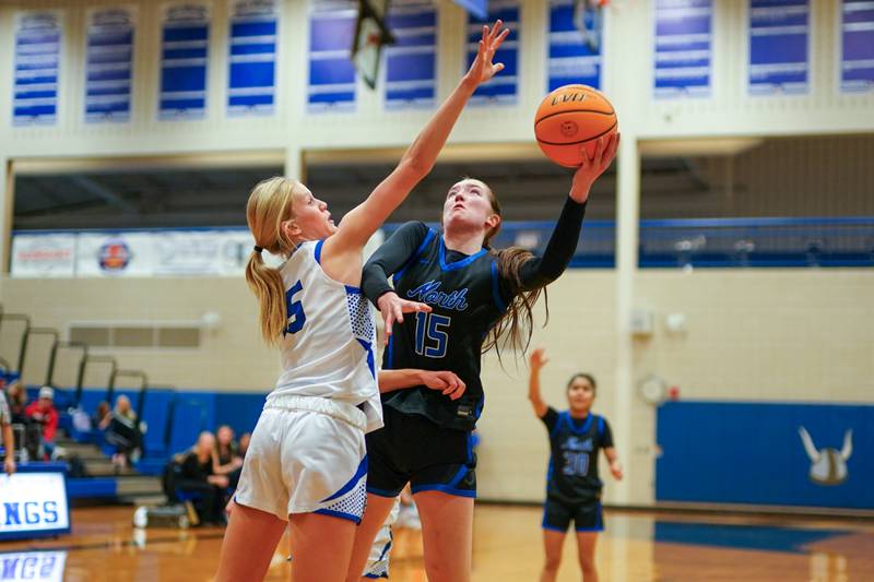 St. Charles North's Bronwyn How (right) shoots the ball in the post against Geneva’s Emma Peterson during a game at Geneva High School on Thursday, Dec. 4, 2025.