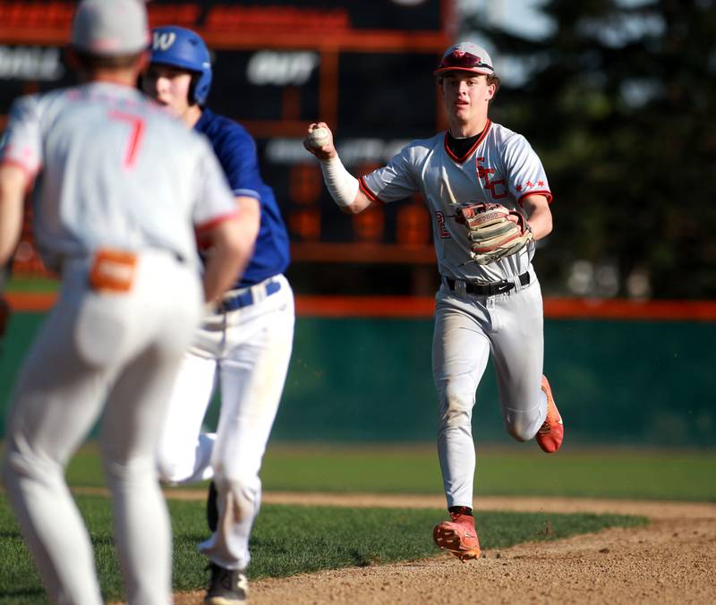 St. Charles East's James Feigleson chases down Wheaton North's Zander Zielinski back to first base during a game on Wednesday, April 23, 2025 in St. Charles.