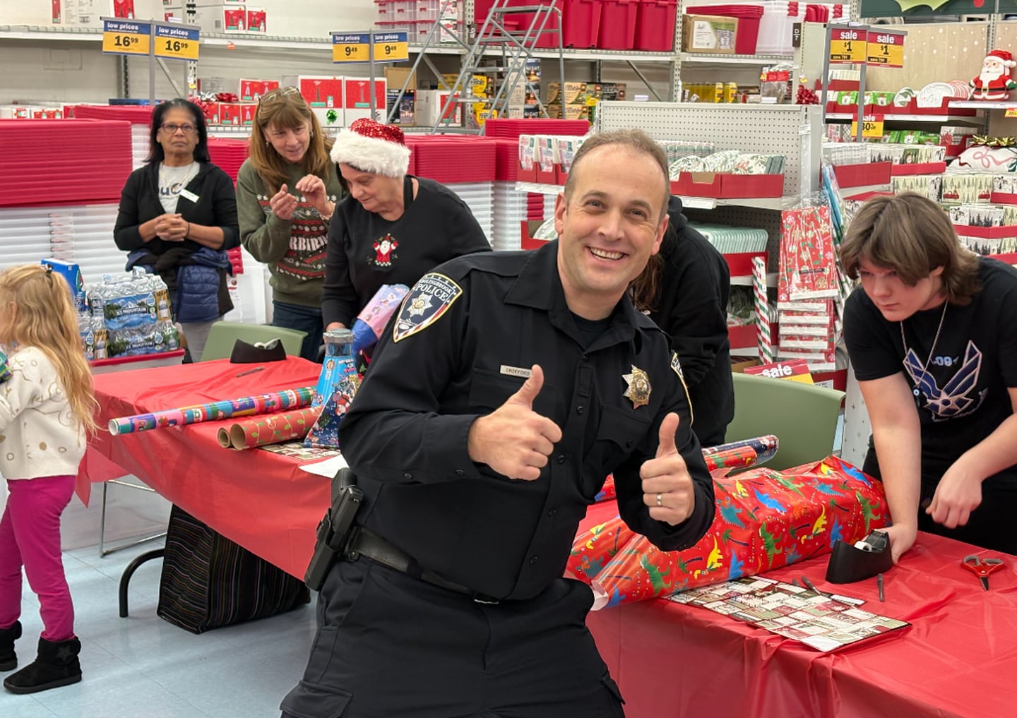 Volunteers with the Bolingbrook Police Department wrap gifts during the Shop With a Cop event at Meijer on Thursday, Dec. 18, 2025.