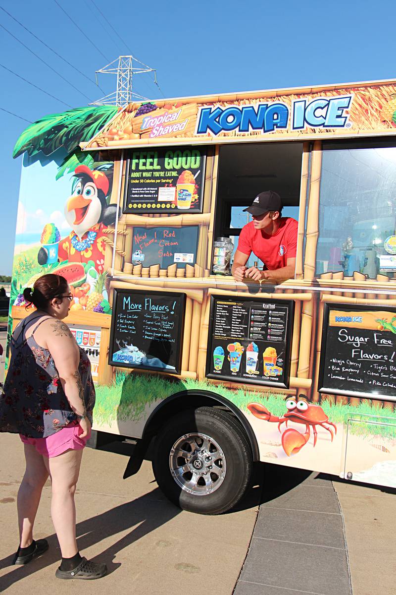 Owen McBride tells customers about the Kona Ice menu Saturday, August 12, 2023 during Venetian Night in Dixon.