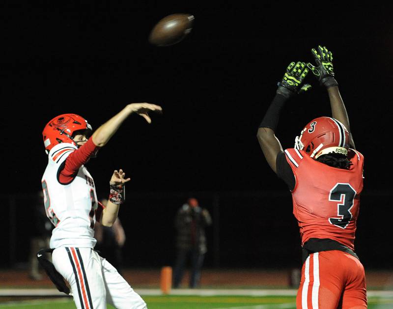 Bolingbrook quarterback Braden Anderson tosses a pass over the out-stretched arms of Yorkville defender Bryce Griffin (3) on Friday, Sept. 27, 2024, during a varsity game at Yorkville High School.