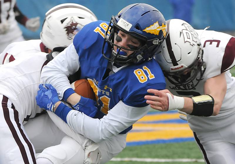 Prairie Ridge's Mason Loucks, left, and Zachary Lindquist, right, tackle Lake Forest's Samuel Gardner during the second quarter of their IHSA Class 6A quarterfinal football game on Saturday, Nov. 13, 2021, at Lake Forest High School.