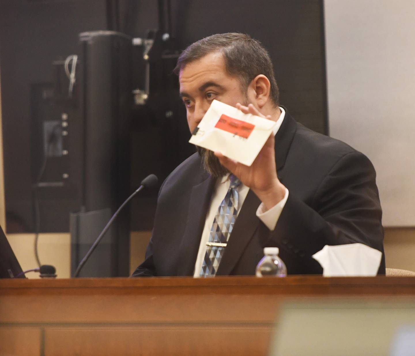 Zeus Flores, a digital forensic expert with the Kane County State’s Attorney’s Office, holds an evidence envelope on Thursday, Jan. 22, 2026 while testifying about extracted data from Duane C. Meyer's cellphone that included  searches for tranquilizer guns and darts three months before his ex-wife was found dead in her Byron home in 2016.